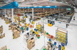 Operarios trabajan en tareas de packing o empaquetado de productos en el almacén