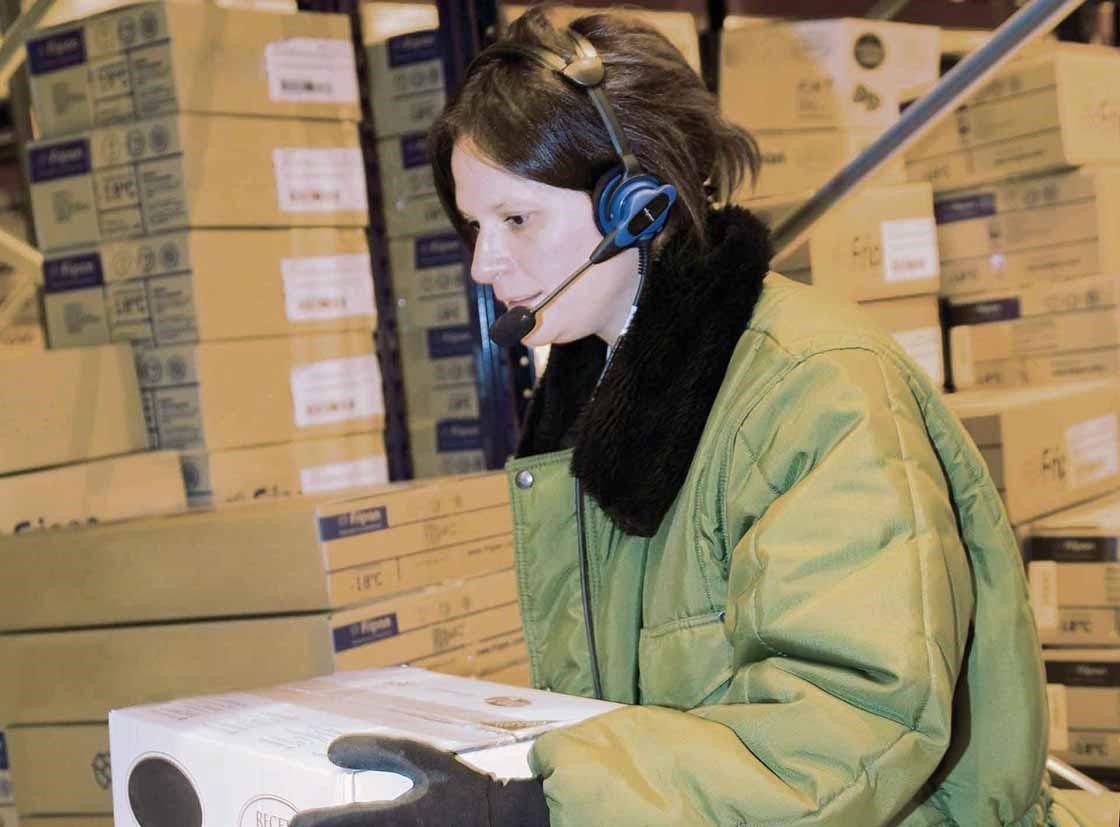 Un operario realiza tareas de preparación de pedidos con un sistema de voice picking Un operario realiza tareas de preparación de pedidos con un sistema de voice picking