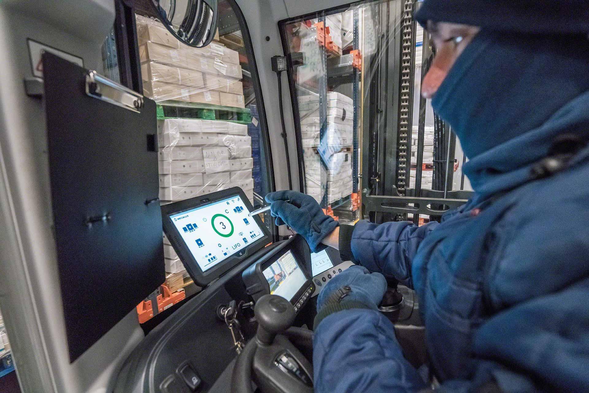Un operario utiliza una tablet en un almacén frigorífico Un operario utiliza una tablet en un almacén frigorífico
