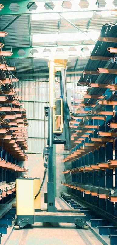 Imagem de um empilhador retrátil de carga lateral num armazém de perfis metálicos