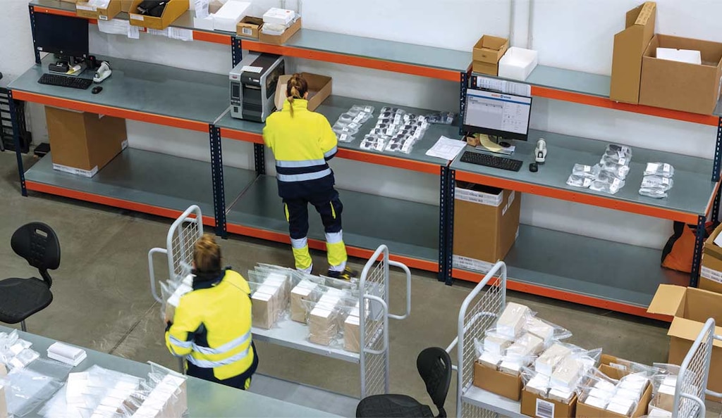 Operario controlando la preparación de pedidos en un almacén para minimizar la pérdida de tiempo de ciclo