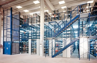 La instalación de montacargas dinamiza el movimiento de mercancías entre niveles en las estanterías con pasillos elevados