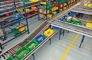 Un circuito de transportadores de cajas conecta las estanterías con las estaciones de picking